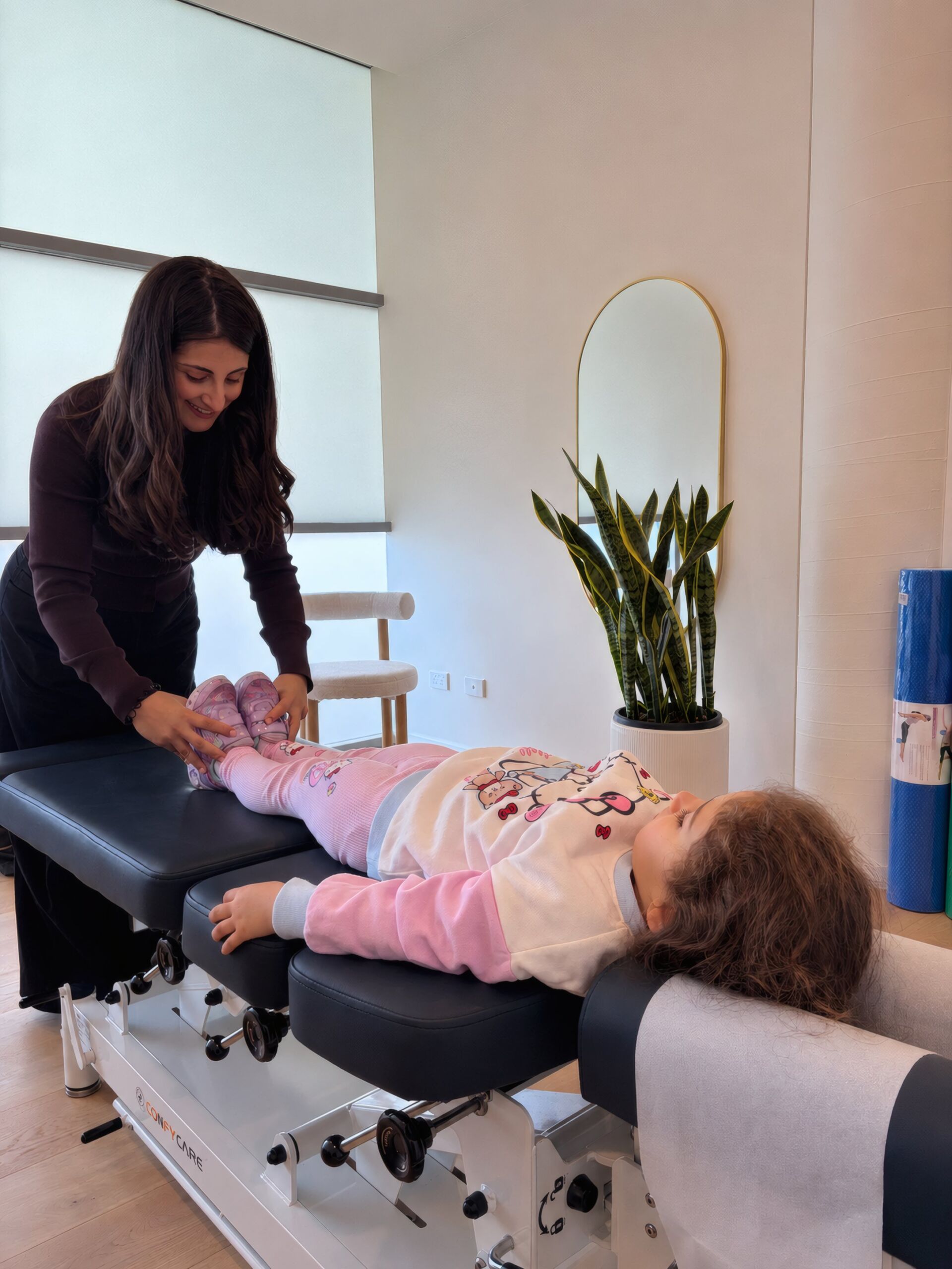 Dr Terri Anne Kayrouz adjusting a young girl